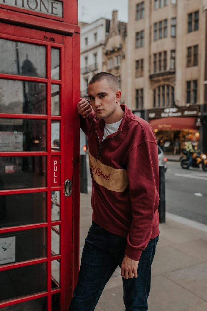 Student posing next to a phone box